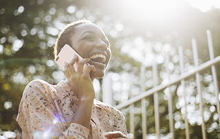 10 Reasons Why You Should Use Voice Broadcasting | Everlytic | Digital Communication Software | Email Marketing | Woman on phone | African woman on phone | Black woman on phone | Woman laughs on phone