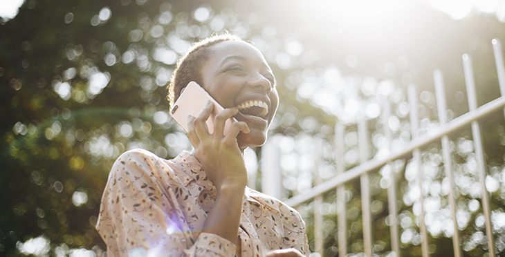 Woman laughing on the phone | African woman on phone