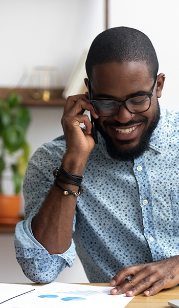 Man smiling with phone | African man on phone
