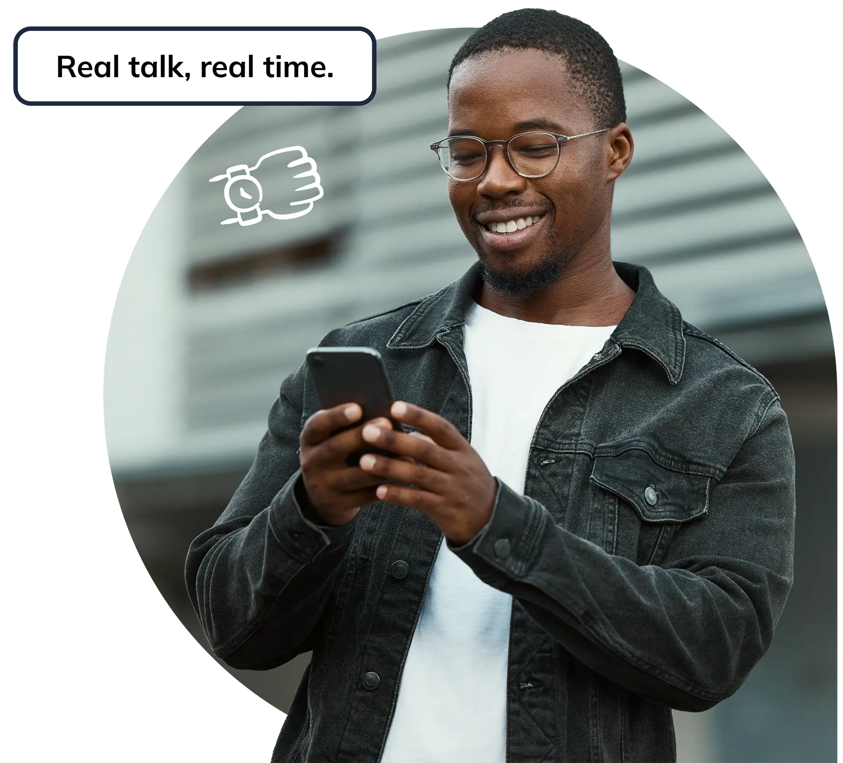 A young man smiling at his phone.