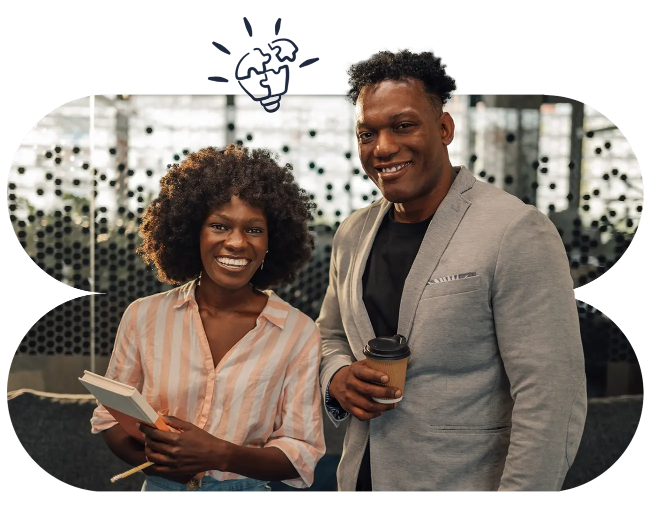 Two work colleagues standing next to each other smiling.