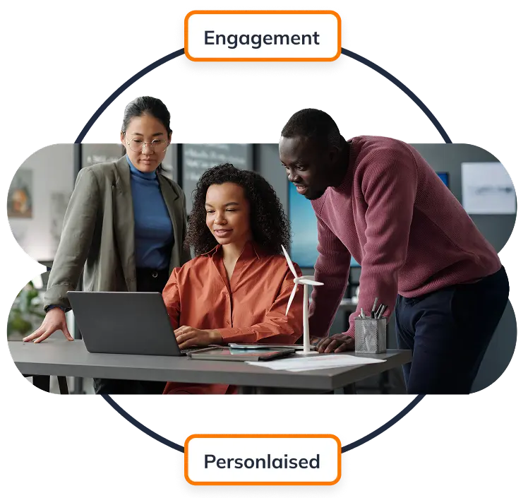 A group of team members huddled together looking at a laptop.