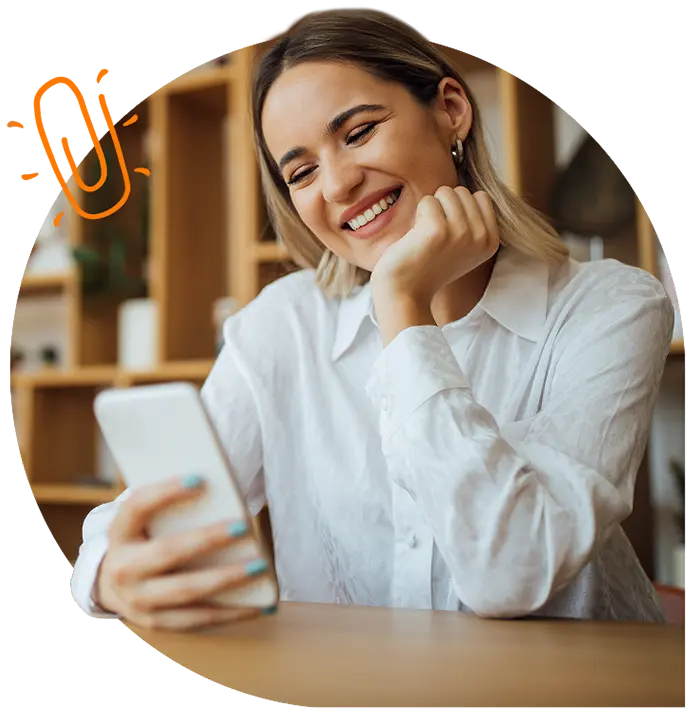 A lady smiling at her phone.