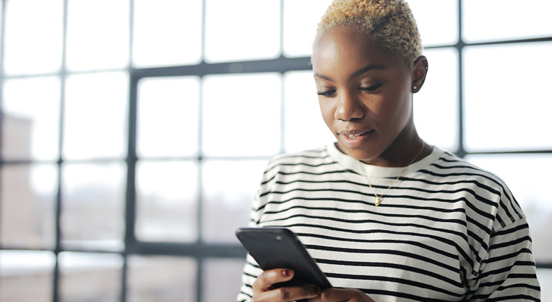 5 Data Compliance Traps to Avoid in SMS Marketing | Everlytic | Woman reading off a cell phone