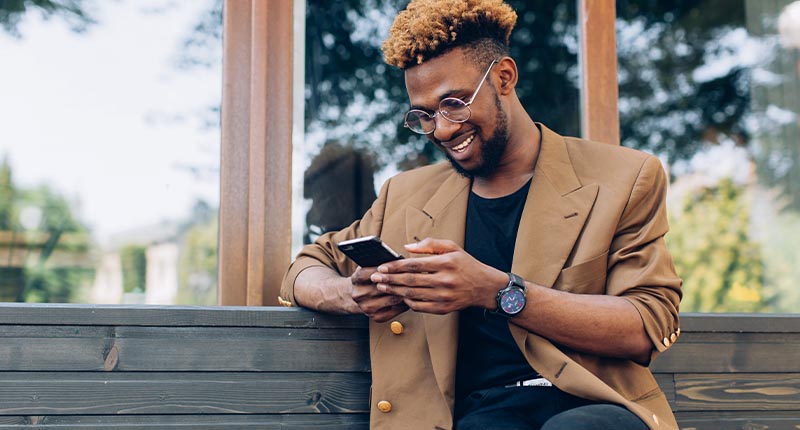 5 Powerful Tips for Crafting Engaging Transactional Email & SMS | Everlytic | Transactional Messaging | Man Reading Off a Cell Phone